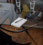 Close-up of a counseling session with two glasses of water and a notepad on a glass table.